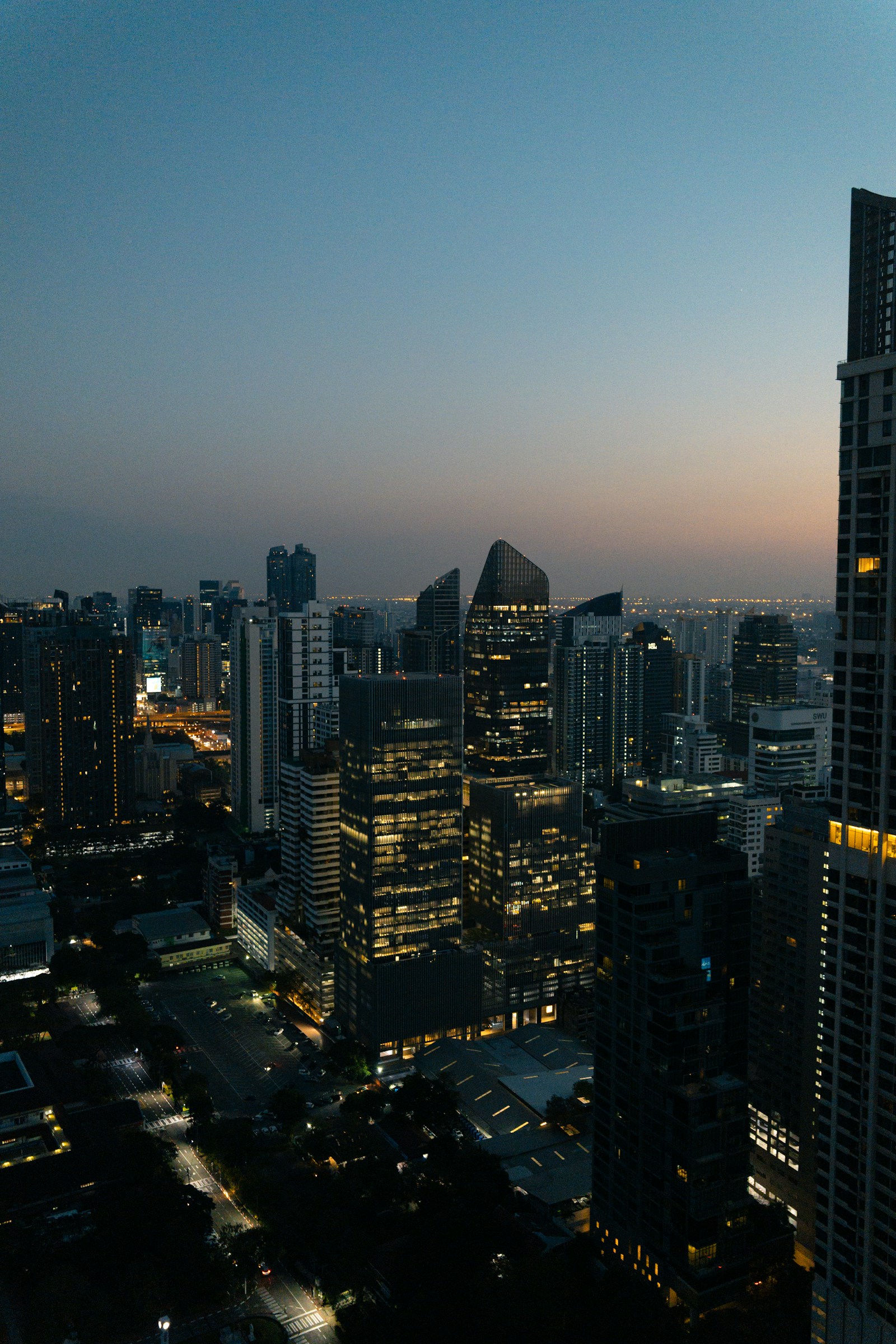 Bangkok skyscrapers illuminated at dusk near Silom