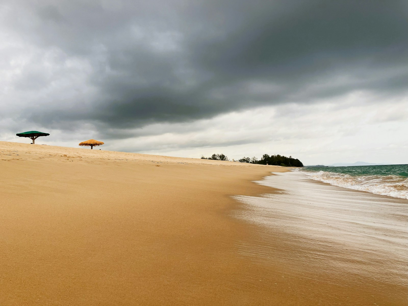 Quiet sandy beach with umbrellas on Phuket's coastline